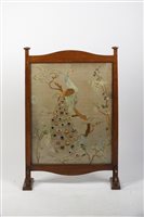 Lot 255 - An Arts and Crafts oak fire screen with silk...