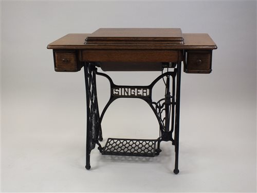 Lot 81 - An oak framed Singer treadle sewing machine on...