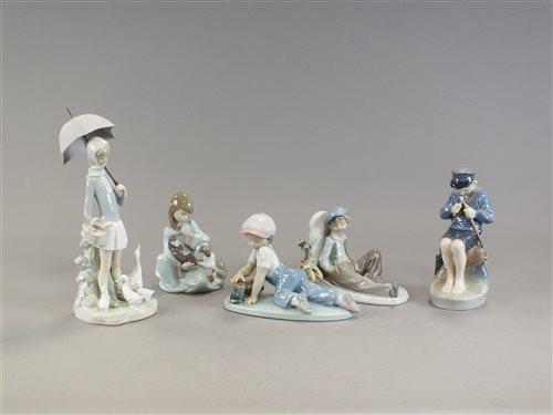 Lot 108 - Lladro: Girl with Umbrella, Boy with Train, Boy Resting, Girl with Puppies. Royal Copenhagen: Boy whittling stick