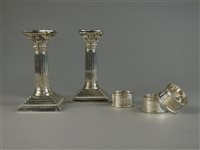 Lot 32 - A pair of electroplate candlesticks and three silver napkin rings
