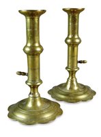 Lot 180 - A pair of George III petal leaf base brass candle sticks