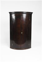 Lot 262 - A George III mahogany and inlaid bow front double door corner cupboard