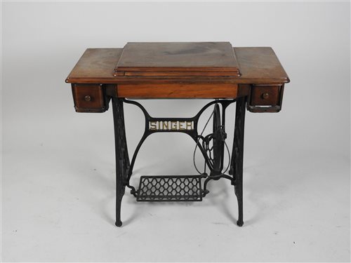 Lot 434 - A Singer sewing machine, in a walnut and cast iron treadle table