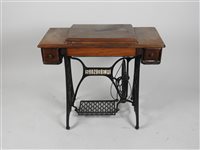 Lot 434 - A Singer sewing machine, in a walnut and cast iron treadle table