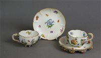 Lot 216 - A pair of Meissen floral encusted teacups and saucers