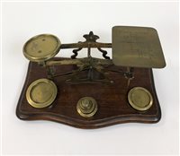 Lot 117 - An Edwardian oak tobacco cabinet and set of brass postal scales (2)