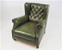 Lot 577 - A green wing back leather armchair