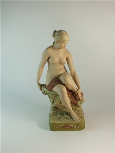 Lot 90 - A Royal Dux figure of a nude female seated upon a rocky base