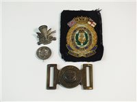 Lot 202 - A Naval belt buckle and three military badges