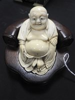 Lot 256 - A Japanese carved ivory figure of Hotei, Meiji period