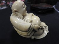 Lot 256 - A Japanese carved ivory figure of Hotei, Meiji period