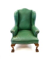 Lot 332 - A George III style green leather wing back armchair