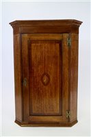 Lot 975 - A George III oak and mahogany cross banded straight front corner cupboard