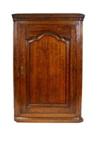 Lot 324 - A George III crossbanded oak straight front corner cupboard