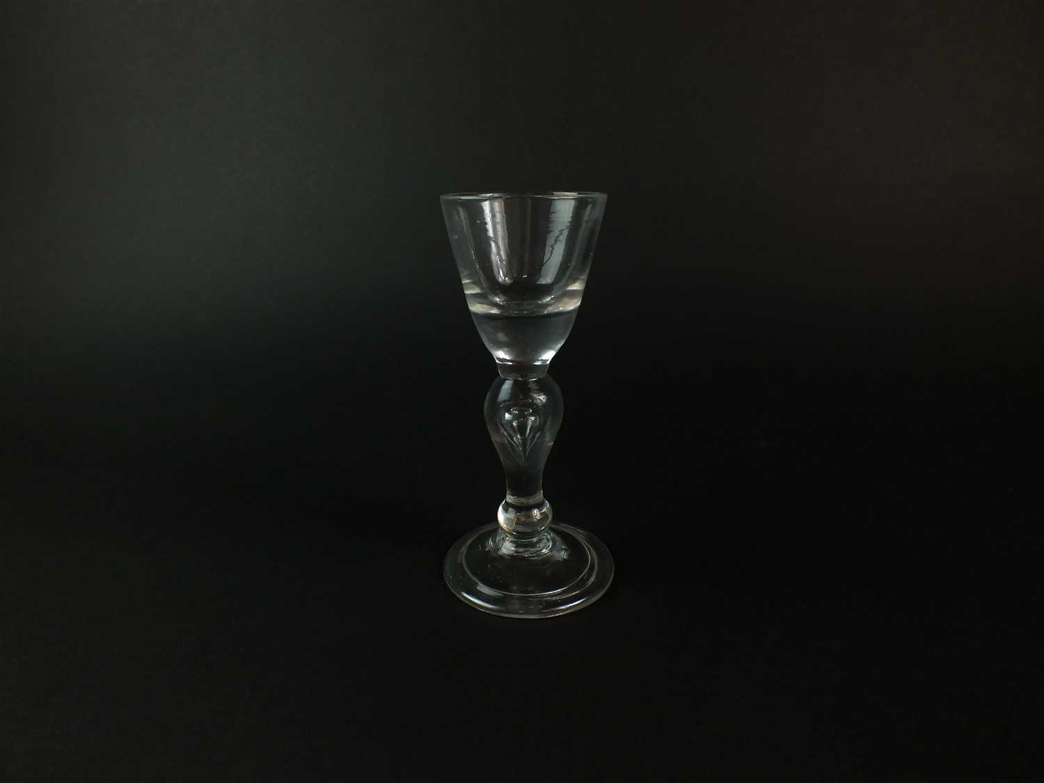 Lot 101 - A heavy baluster wine or dram glass, circa 1710