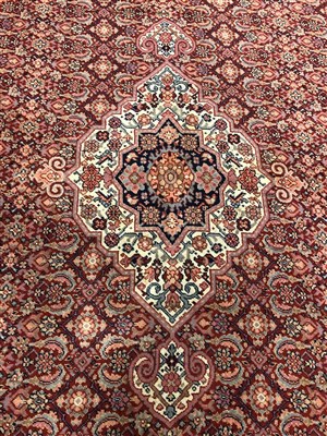 Lot 1050 - A large Eastern woven wool carpet