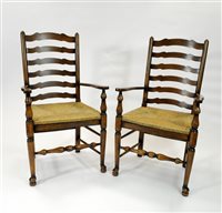 Lot 715 - A pair of good quality reproduction stained oak rush sated leather back arm chairs