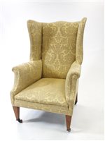 Lot 994 - An upholstered wing armchair