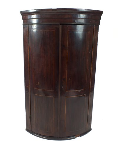 Lot 633 - A large George III mahogany barrel fronted corner cupboard