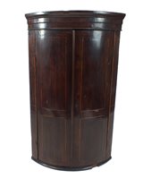 Lot 633 - A large George III mahogany barrel fronted corner cupboard