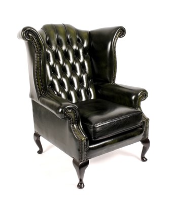 Lot 803 - A George III style green faux leather upholstered wing arm chair of generous proportions