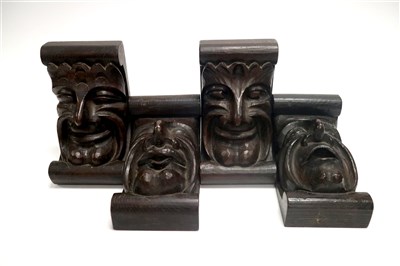 Lot 360 - A set of four carved stained oak mask brackets