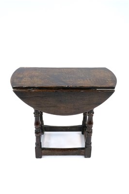Lot 821 - A very small 18th century style country oak gate leg table