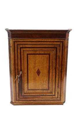 Lot 494 - A George III cross banded oak corner cupboard