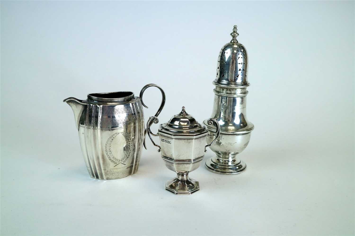 Lot 128 - A silver cream jug, sugar caster and trophy cup