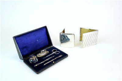 Lot 142 - Two silver cigarette cases and a manicure set
