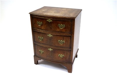 Lot 450 - A small cross-banded bow fronted chest of three drawers