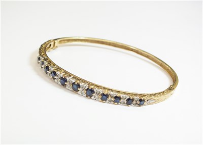 Lot 82 - A 9ct gold sapphire and diamond hinged bangle
