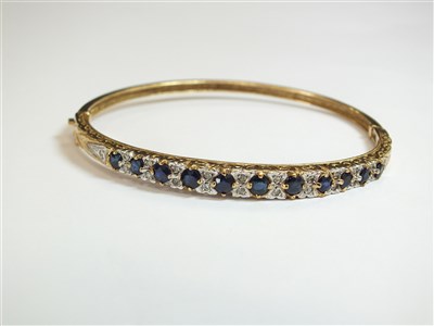 Lot 82 - A 9ct gold sapphire and diamond hinged bangle