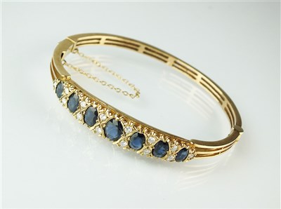Lot 328 - A 9ct gold sapphire and diamond bangle