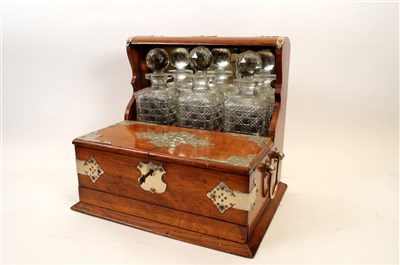 Lot 716 - A Victorian oak three decanter tantalus with silver-plated mounts and an oak drinks tray