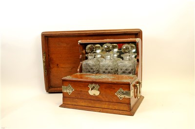 Lot 716 - A Victorian oak three decanter tantalus with silver-plated mounts and an oak drinks tray