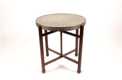 Lot 568 - An early 20th century Arabic brass topped occasional table raised on a folding mahogany frame