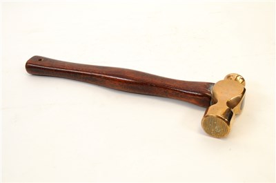 Lot 540 - An early 20th century bronze headed hammer with a shaped mahogany handle