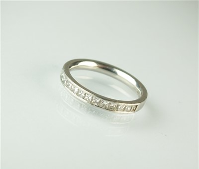 Lot 75 - A platinum half hoop eternity ring