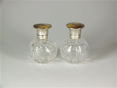 Lot 193 - A pair of silver and Stinton enamel topped glass scent bottles