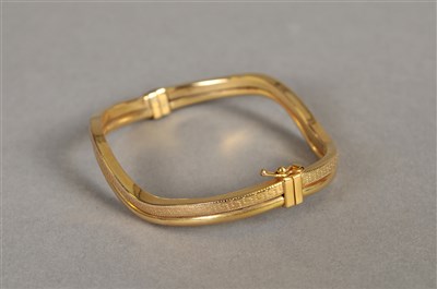 Lot 87 - A 9ct gold stylised wave hinged bangle