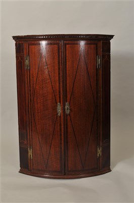 Lot 376 - A George III oak barrel-fronted corner cupboard