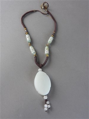 Lot 95 - A Chinese white jade pendant of oval...