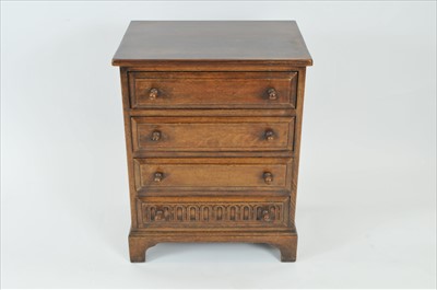 Lot 766 - A reproduction rustic oak chest of four long drawers in the old English style