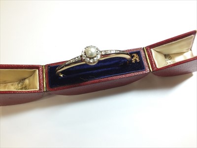 Lot 60 - A late 19th century untested pearl and diamond hinged bangle