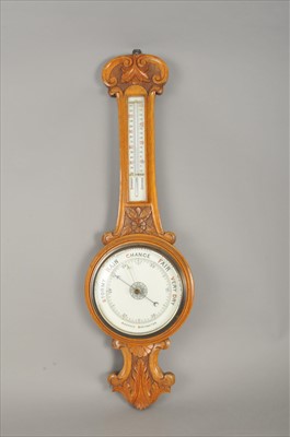 Lot 450 - An early 20th century carved oak wall-hanging banjo barometer