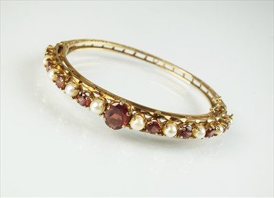 Lot 84 - A 9ct gold garnet and pearl bangle