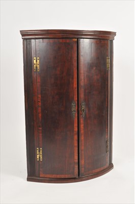 Lot 589 - A George III mahogany bow front corner cupboard
