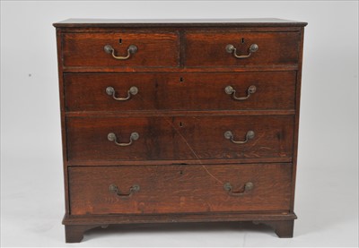 Lot 565 - A George III style country oak chest of two long and three graduating long drawers