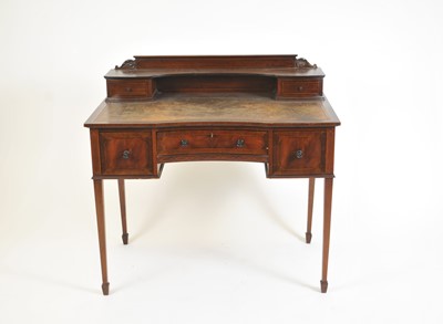 Lot 380 - A reproduction mahogany writing desk in the manner of Maple & Co